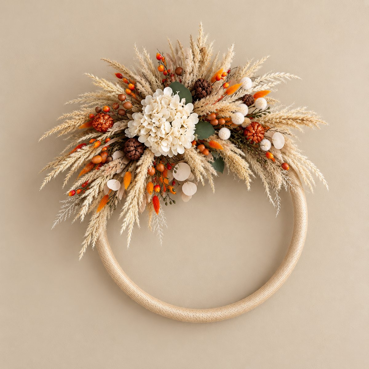 Bespoke wreath with cream flowers, dried grasses, orange accents and a wrapped circular frame.